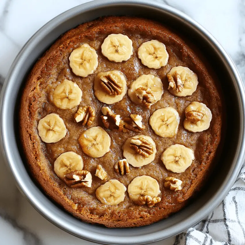 Part de gâteau moelleux à la banane, sans farine, sans sucre ajouté ni lait, servie sur une assiette en céramique avec une cuillère en bois.